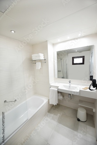 Contemporary bathroom featuring a large bathtub, a pedestal sink, and a spacious stand-up shower