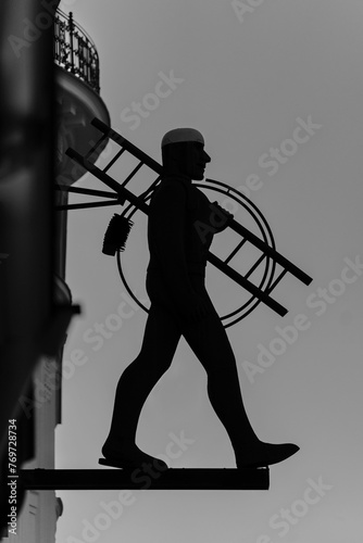 Bronze sculpture of a man: chimney sweeper rauchfangkehrer silhouette in Vienna photo