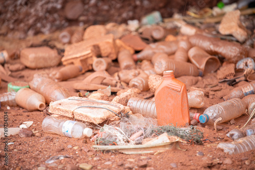 an orange jug sits on top of some garbage near bottles