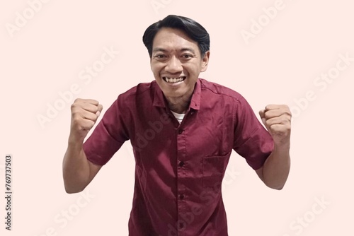 Excited young handsome Asian man celebrating victory or success with arms raised. People's lifestyle concept