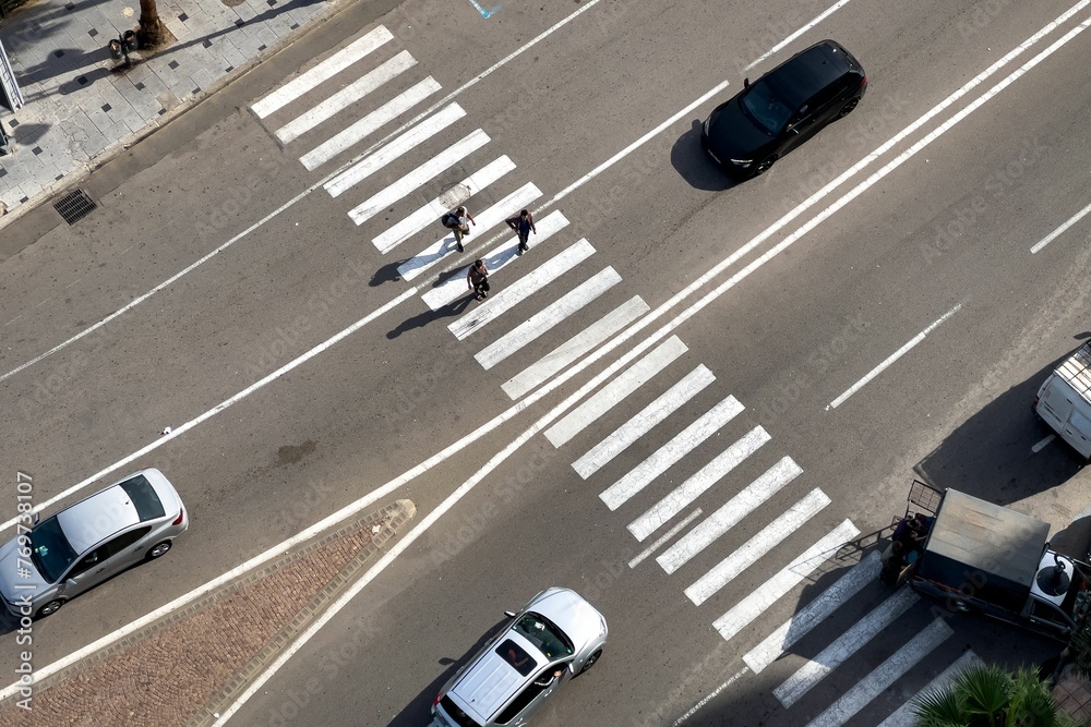 Fototapeta premium Aerial view of Pedestrians crossing the zebra lines