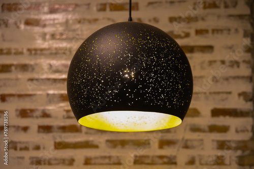 A hanging ceiling lamp that was turned on and let light shine through in small spots. Looks like a star