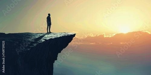 A person is standing on a cliff overlooking a beautiful sunset