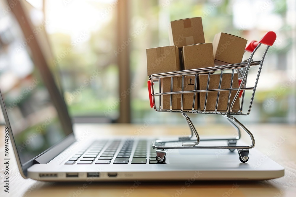 Imagine a symbolic online shopping concept where a cart filled with boxes is perched on a laptop computer. This visual metaphor conveys the essence of digital retail