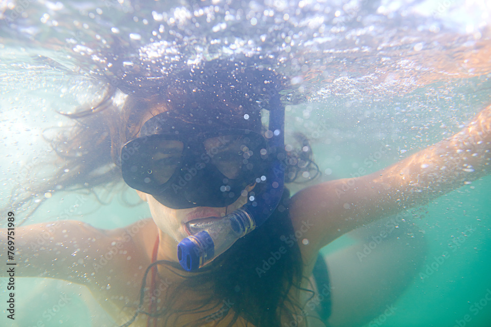 Woman, snorkeling and swimming on holiday in water, sport and diving for travel, fun and activity. Scuba, diver and mask in underwater, sports and adventure with equipment, pool or reef on vacation