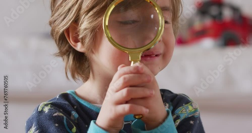 Cute kid boy using magnifying glass