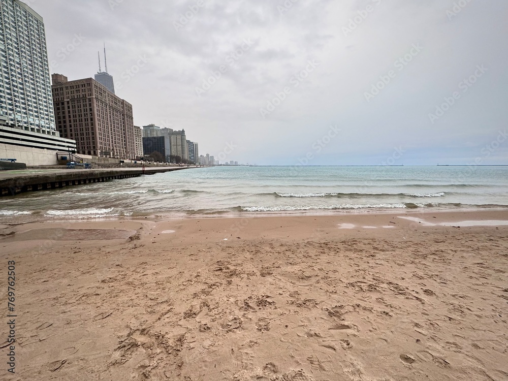 view of a sandy beach on Lake Michigan in Chicago with the city buildings in the background on a cloudy and cold winter day
view of a sandy beach on Lake Michigan in Chicago with the city buildings in the background on a cloudy and cold winter day