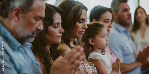 A group of family and friends praying together during the christening ceremony. 