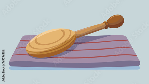  A rounded wooden tool with smooth tapered edges sits on a cloth surface used for acupressure massage.