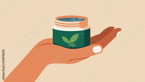  A closeup of a practitioners hand holding a small jar of ointment made from a blend of Chinese herbal extracts used to soothe and heal the skin
