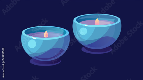  A pair of small glass cups with rounded edges used for cupping therapy glowing in soft candlelight.
