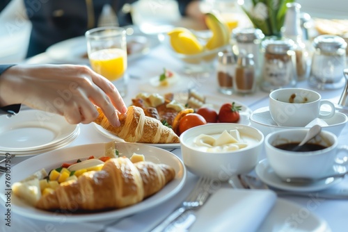 neatly arranged continental breakfast, diner reaching for croissant photo
