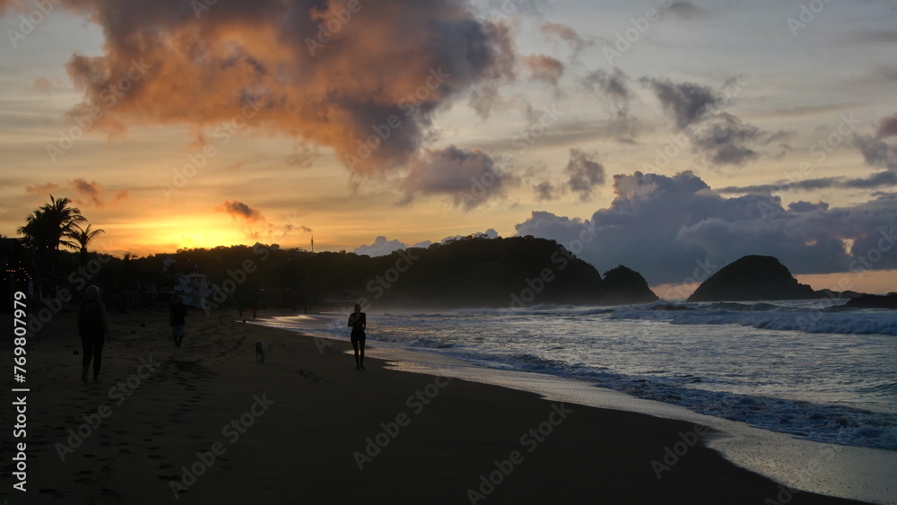Person walking on the beach at sunrise in Zipolite, Mexico