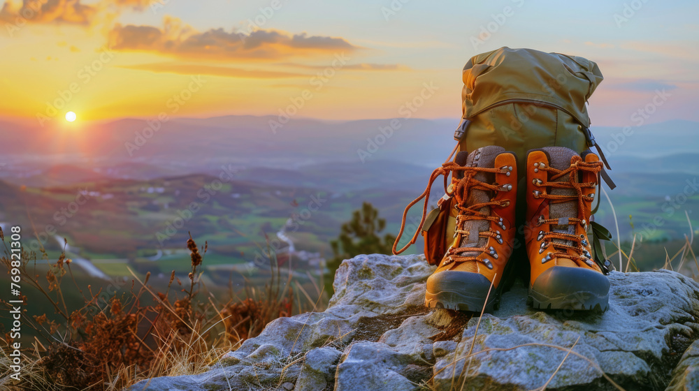 Perched atop a lofty hill or rocky precipice, orange hiking shoes and a backpack await their next trek. - obrazy, fototapety, plakaty 