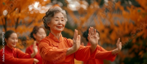 Asian elderly women in red do Tai Chi, surrounded by autumn leaves, in the style of Chinese art. photo