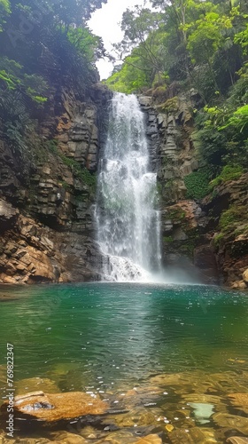 The serene beauty of a cascading waterfall in a dense jungle setting  where nature s music and lush foliage create a tranquil haven.