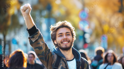Joyful young man with raised fist celebrating unity in protest. Concept: strike, unity, activism, rights engagement, city life, climate change and social movements