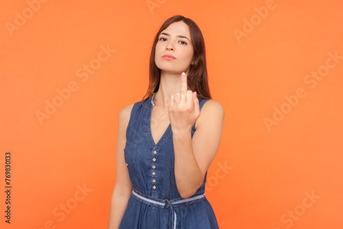 Canvastavla Portrait of rude impolite brunette woman wearing denim dress showing middle finger suck sign arguing with somebody aggressive behavior