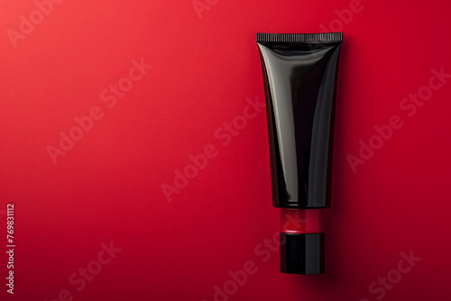 Sleek cosmetic cream tube in a glossy black design against a bold red isolated solid background, reflecting contemporary chic, © PNG Transparent 