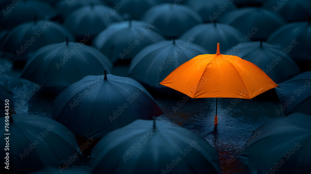 Obraz premium Stand Out in a Crowd: A Lone Orange Umbrella Among Black Ones