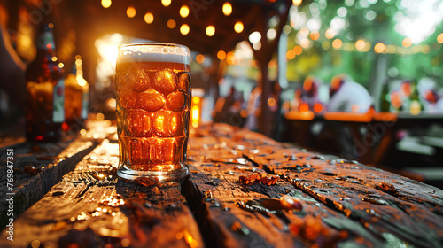 Close-up of beer glass standing on the table of the street terrace of a pub and people gathering on background. photo