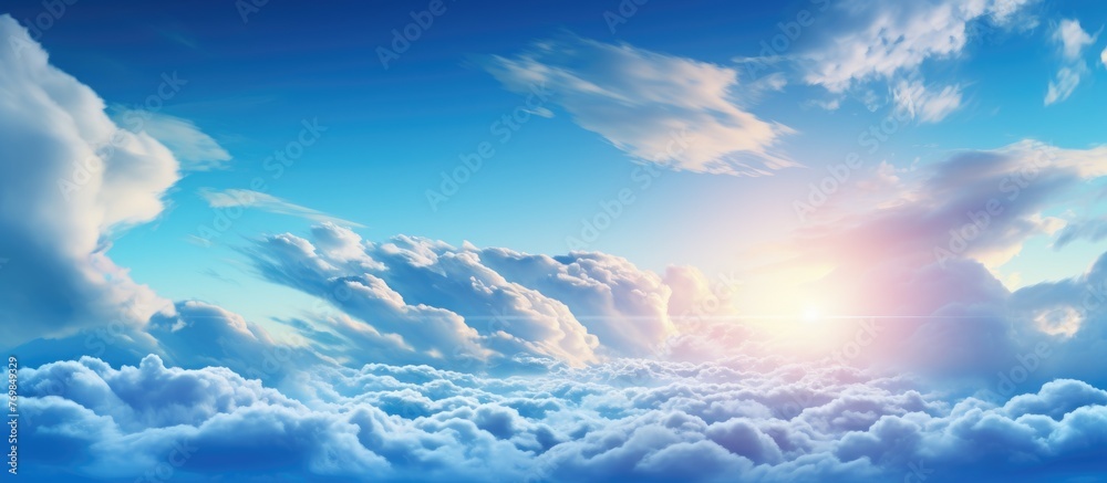 The sun is illuminating the sky with scattered clouds, creating a stunning natural landscape with shades of blue and fluffy cumulus clouds