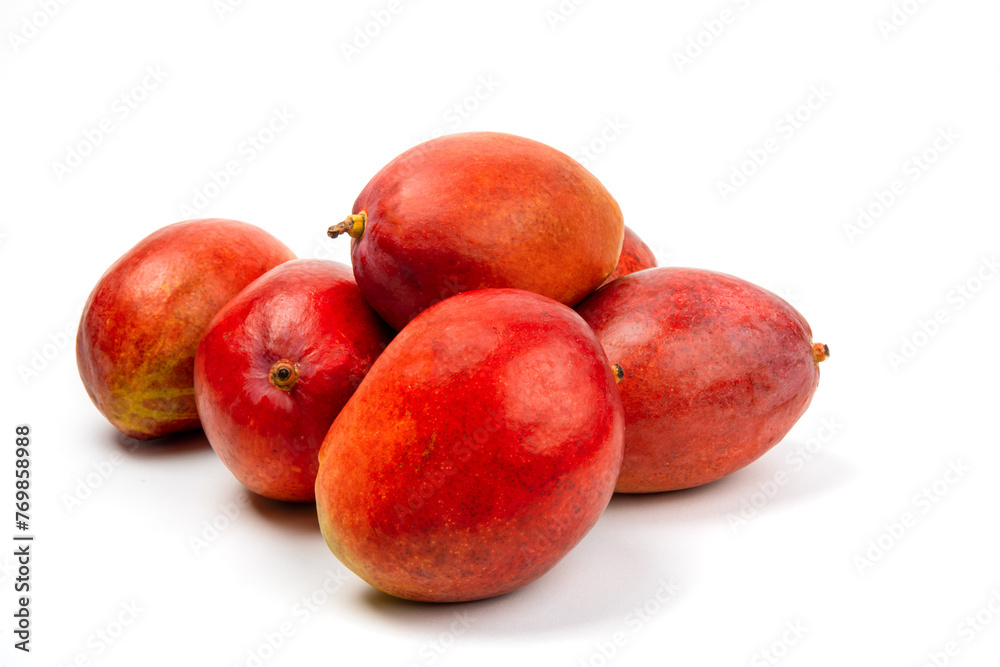 a pile of ripe natural looking red mangoes on a white table top isolated on white a pile of ripe natural looking red mangoes on a white table top isolated on white