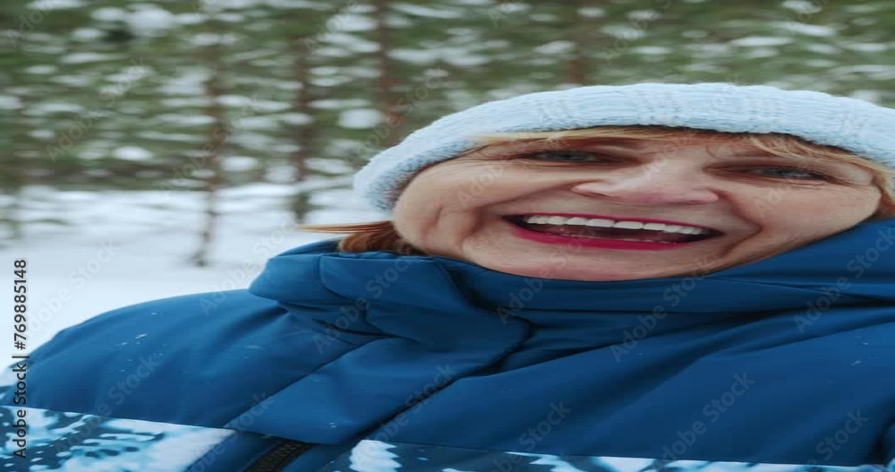 The view from the phone camera during a video call. A happy retired woman in a blue tracksuit communicates via video link while walking through a winter forest. High quality 4k footage The view from the phone camera during a video call. A happy retired woman in a blue tracksuit communicates via video link while walking through a winter forest. High quality 4k footage