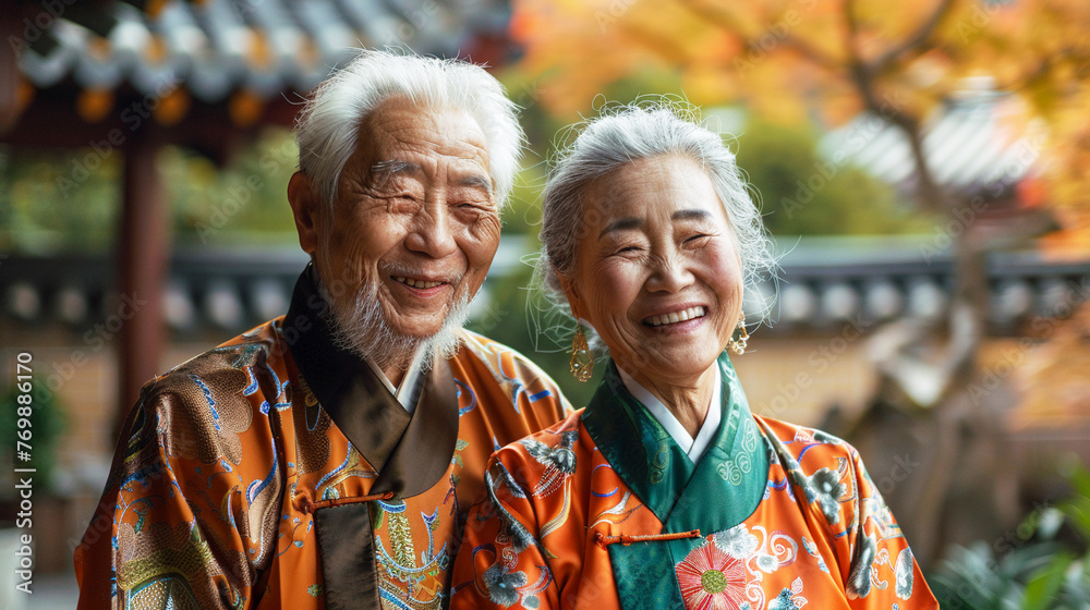 A portrait of a joyful elderly Chinese couple in a traditional garden their white hair complemented by their vibrant orange and green silk outfits