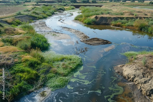 A river flows through a green field, part of a restoration site to improve water quality and restore natural habitats