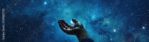 A hand reaching for a star in the night sky illustrating the pursuit and achievement of ones dreams photo
