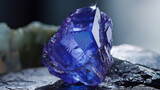 A mesmerizing deep blue sapphire crystal prominently stands out against a moody, dark background with subtle highlights