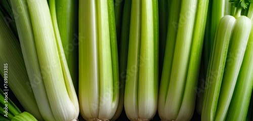  A group of celery stalks arranged on top of a mound of various vegetables