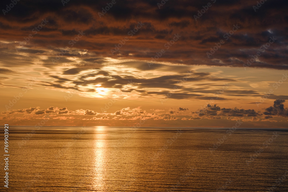 Romantic colorful sunset at the sea. View of Beautiful glorious golden sunset and golden hour above the sea in evening.