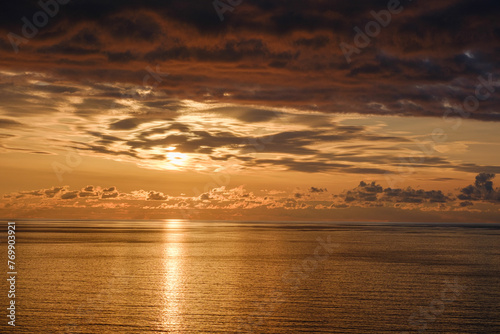 Romantic colorful sunset at the sea. View of Beautiful glorious golden sunset and golden hour above the sea in evening.