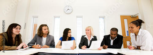 Office colleagues.  A business meeting in a neutral modern office environment between a group of smartly dressed professionals. photo