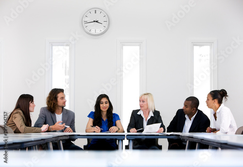 Office colleagues.  A business meeting in a neutral modern office environment between a group of smartly dressed professionals. photo