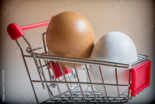 Shopping cart with two chicken eggs, conceptual image