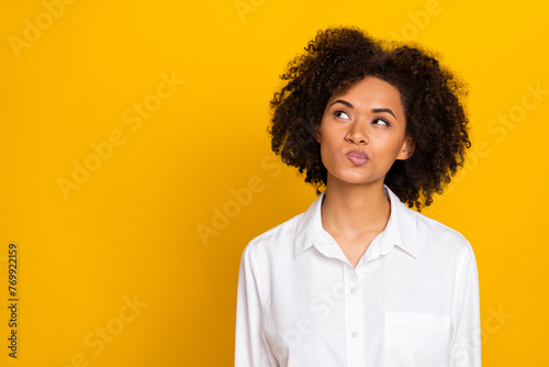 Portrait of attractive suspicious funny wavy-haired girl thinking copy space isolated over bright yellow color background