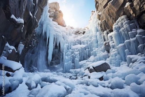 Frozen waterfall with icicles and snow-covered rocks.