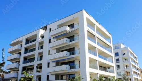 A modern apartment building with geometric shapes and white exterior walls, under the bright sun on a clear day against a blue sky Generative AI