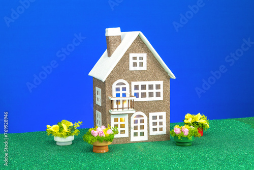 One low brown house with flowers around on a blue background
