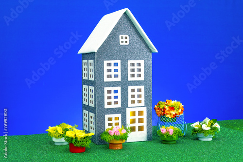 One gray house with flowers around on a blue background