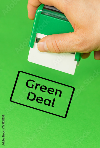 Obraz na płótnie Official putting a stamp approving the Green Deal, Green background, vertical, copy space w salonie