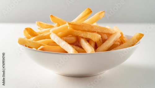 the fresh yummy french fries in a white bowl isolated on a clear white background shot in a studio