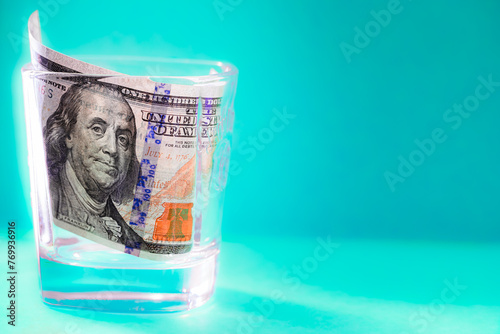100 dollar bill in whiskey glass