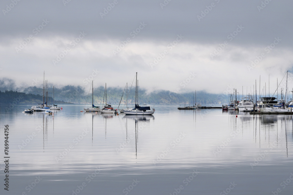 Boats in front of the shore of Cowichan Bay during a winter season on Vancouver Island in British Columbia, Canada