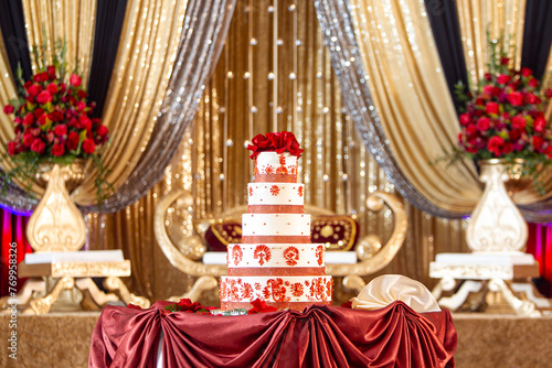 Elegant Indian wedding reception decor with cake and golden stage