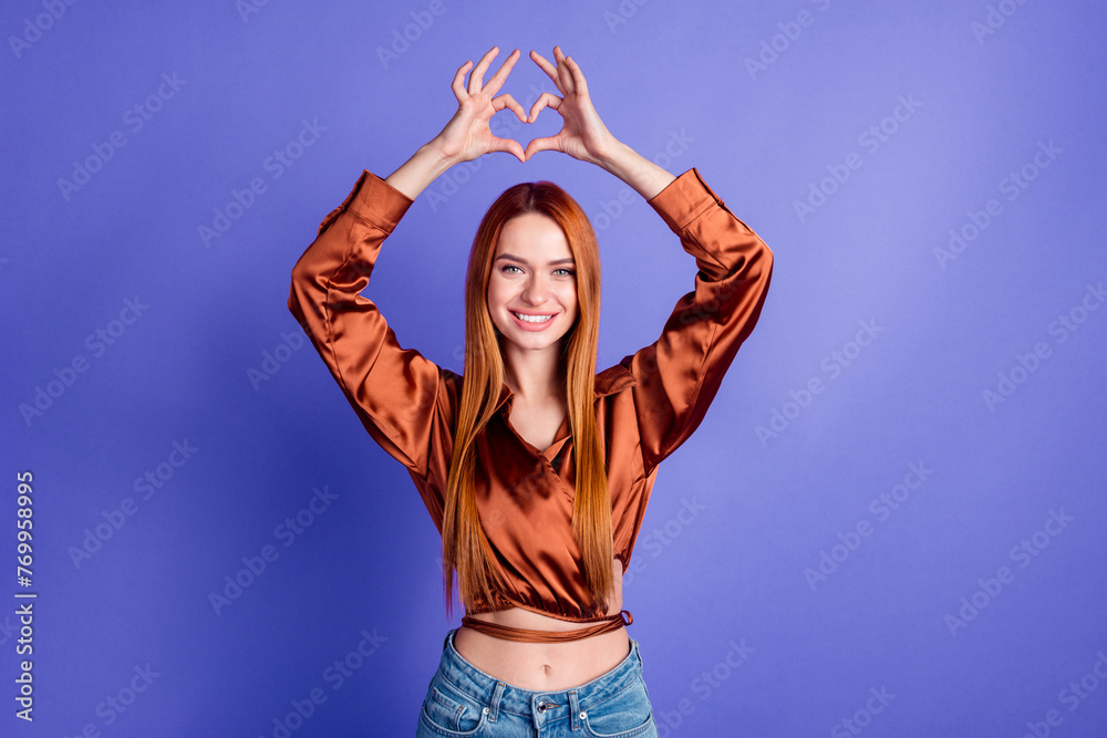 Portrait of nice young woman fingers show heart symbol wear brown shirt isolated on purple color background - obrazy, fototapety, plakaty 