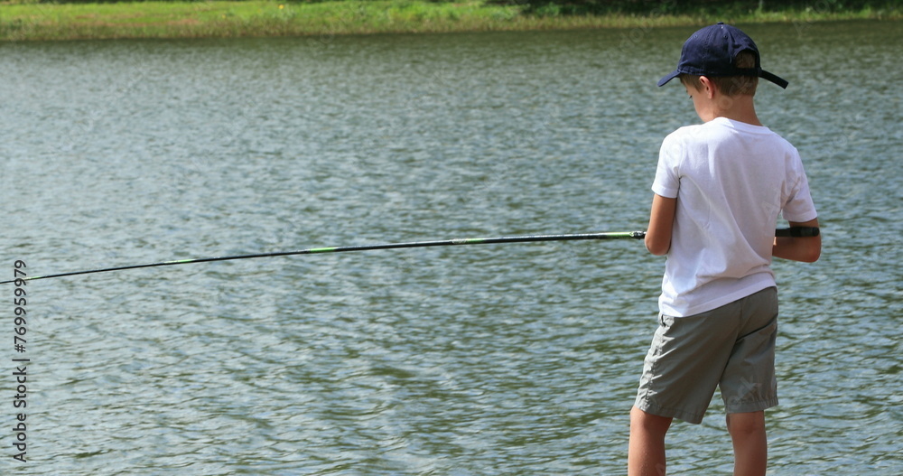 Child fishing at the lake, young boy relaxing at outdoor activity Child fishing at the lake, young boy relaxing at outdoor activity